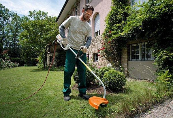 Cortar a grama com um aparador de jardim