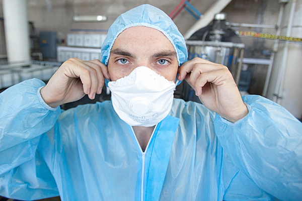 Man in beschermende jas en gasmasker