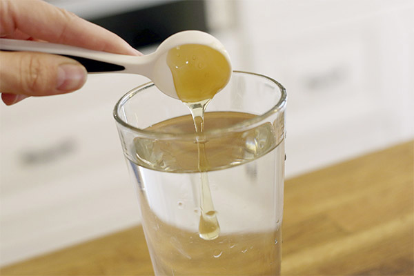 إضافة العسل إلى كوب من الماء